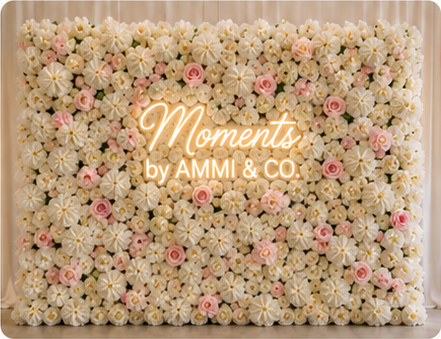 Blush and ivory flower wall with Moments by AMMI & Company LLC logo