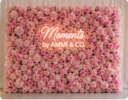 Pink flower wall with Moments by AMMI & Company LLC logo