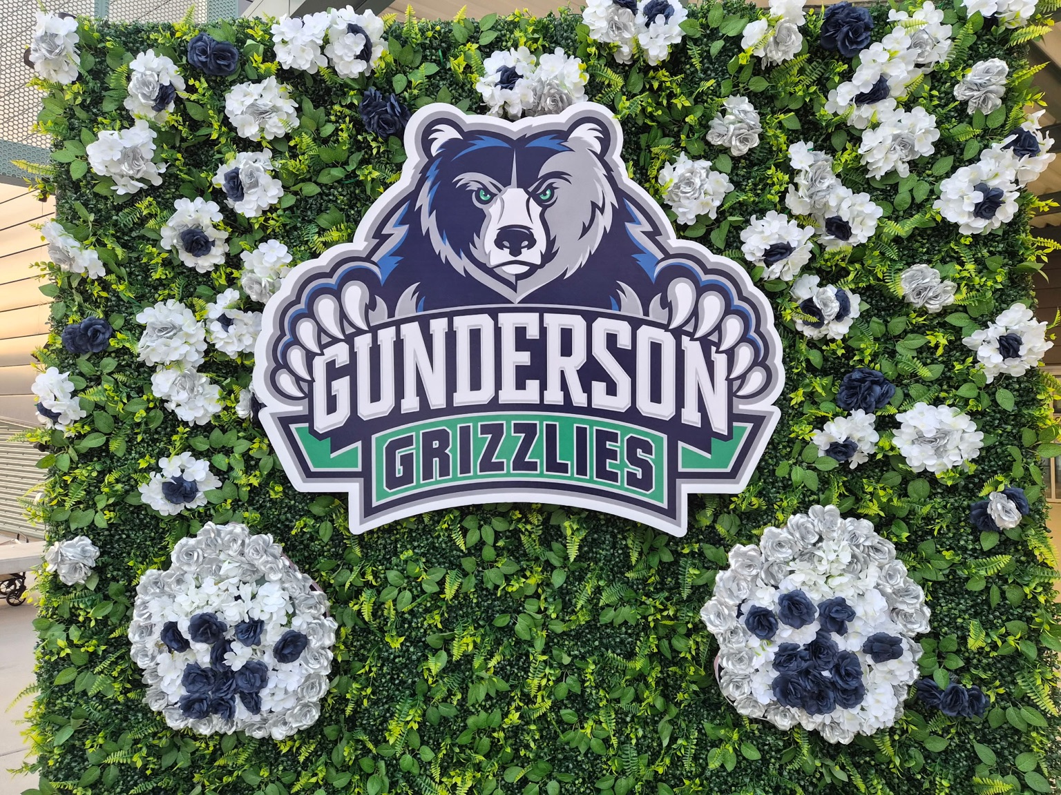 Close view of the Gunderson Grizzlies floral greenery wall and flower-covered paw prints